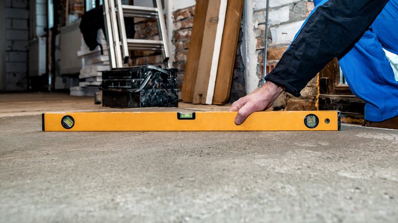 Person using a level to test a concrete floor