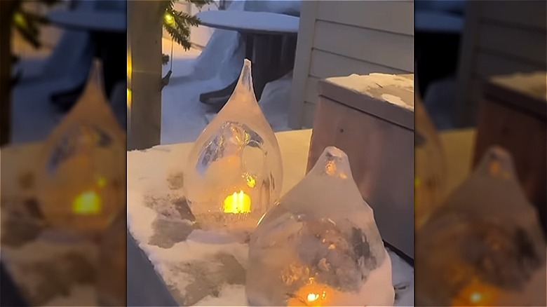 Two ice lanterns made from frozen water balloons decorate a front porch