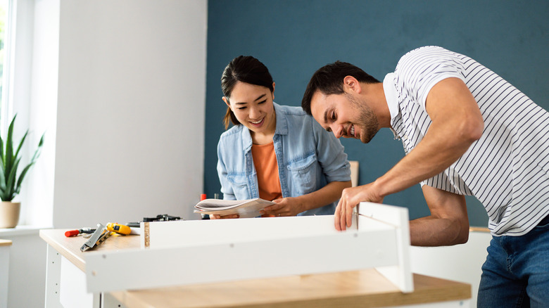 man and woman assemble furniture