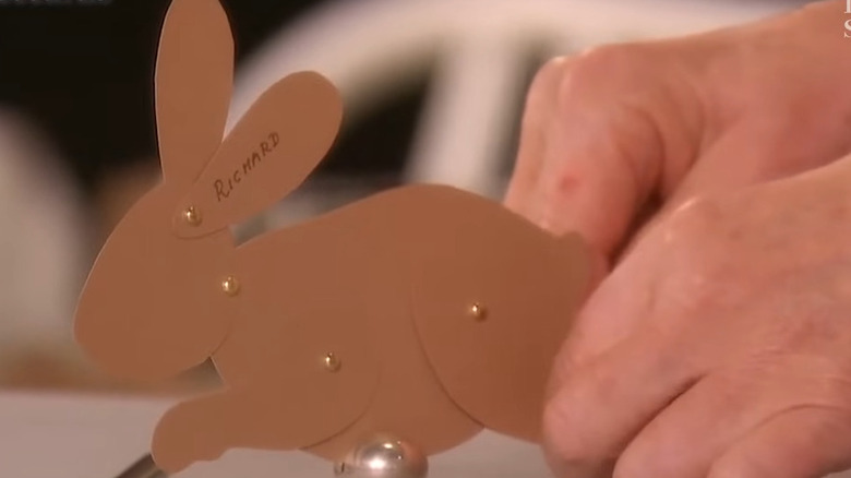 Hand holding a brown cardstock bunny joined by brads