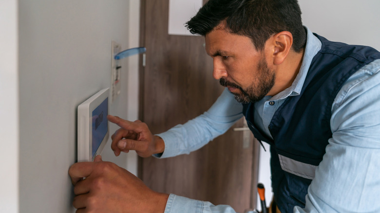 A technician installing a home security system