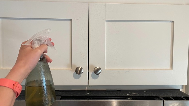 Hand spraying white cabinets