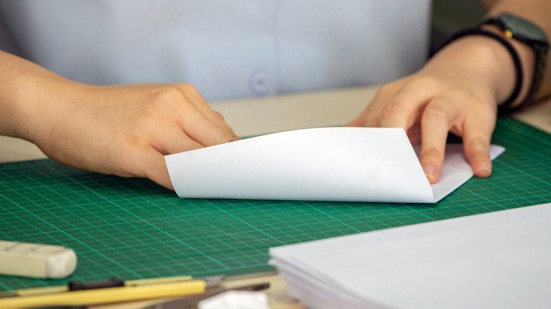 Someone folding white paper for a DIY