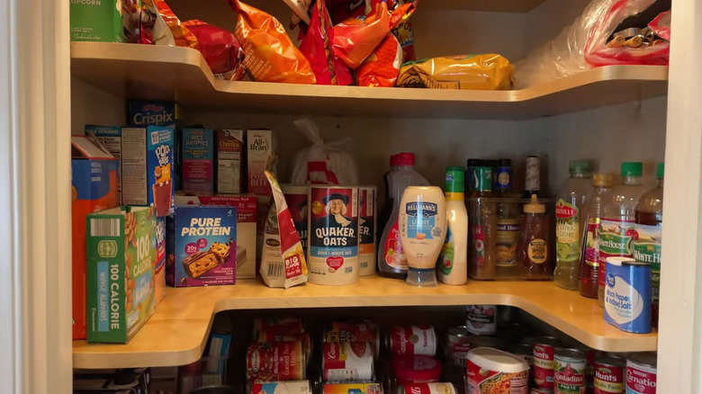 Horseshoe-shaped shelves in a closet pantry filled with food