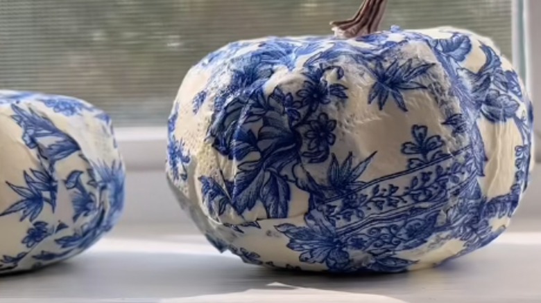 Two chinoiserie pumpkins on a windowsill