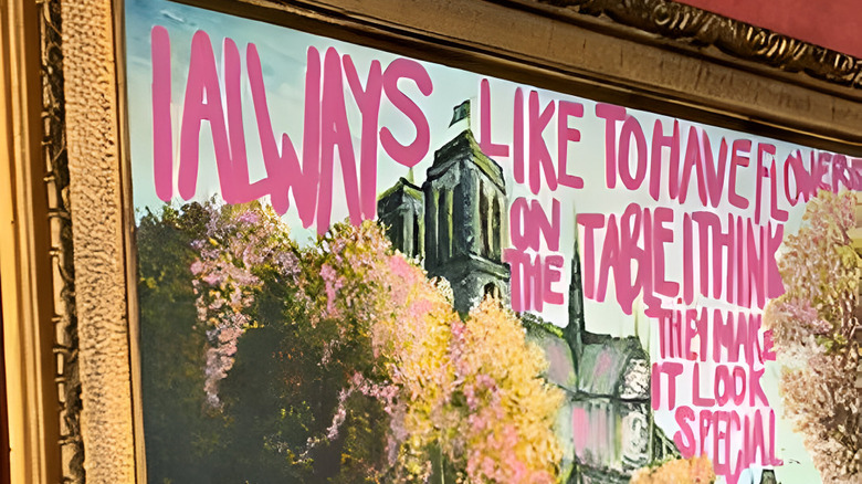 Pink painted words on thrifted art