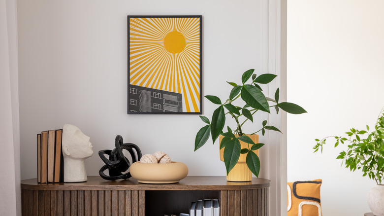 Pop art sun on a white wall over an artistically decorated table