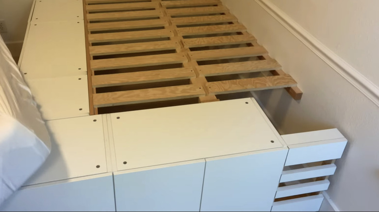 A bed frame with storage and wooden slats.