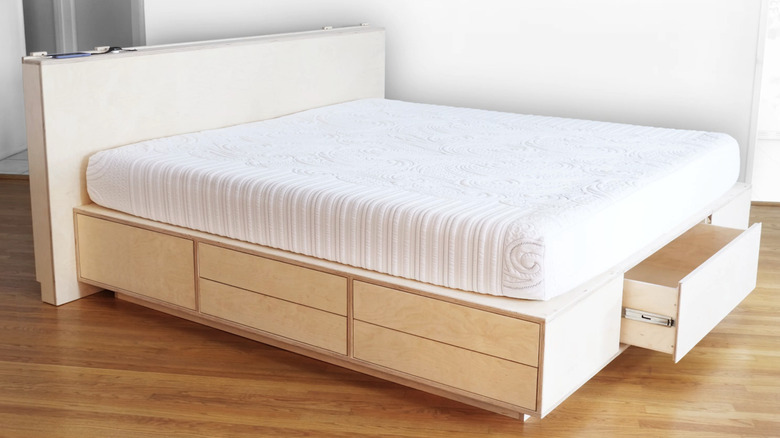 A light wood bed frame with drawers.