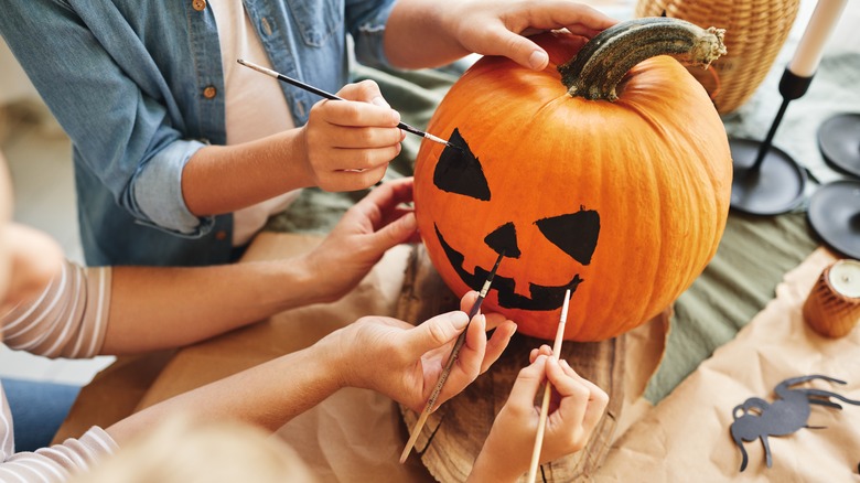 People painting a pumpkin