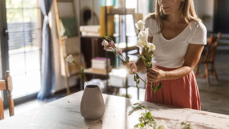Person creating floral centerpiece