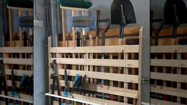 Garden tools sit neatly in a rack made out of a wooden pallet