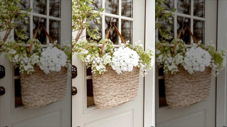 Door wreath made from a straw handbag with white flowers sticking from the top