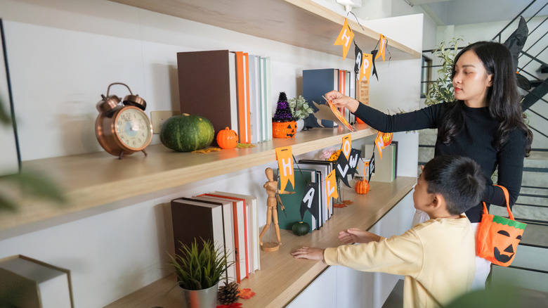 A mother and son decorate for Halloween