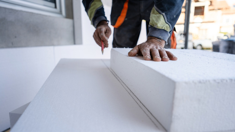 Person cutting styrofoam.