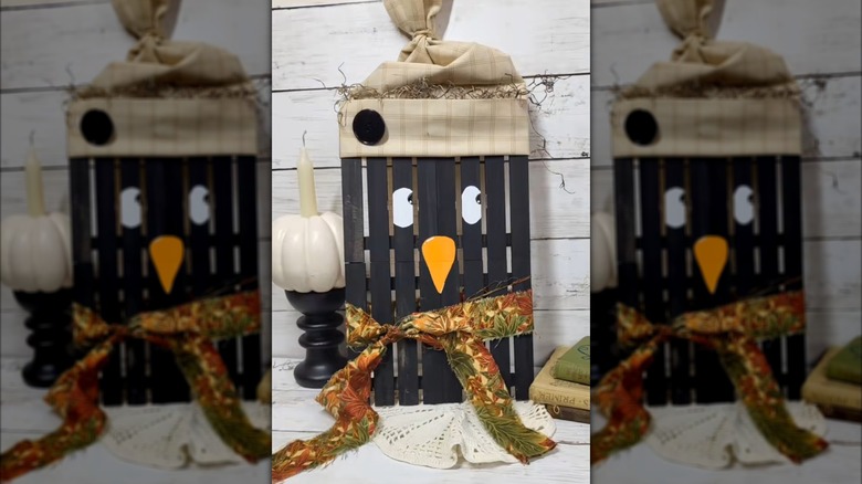 A black raven painted onto Dollar Store miniature wood pallets
