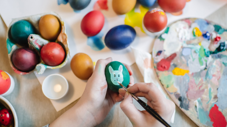 A person hand painting eggs for Easter decor