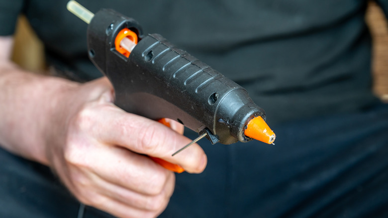 A person holding glue gun