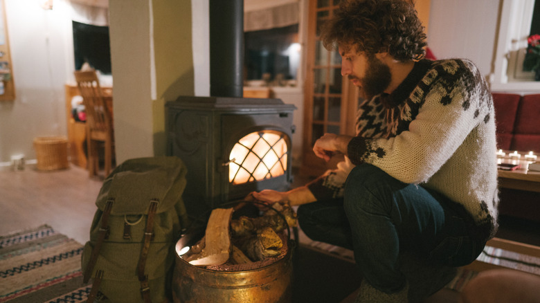 person sitting beside wood stove