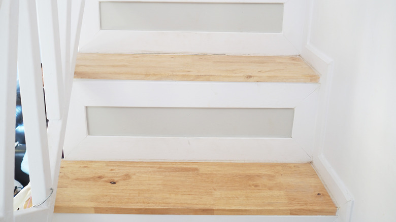 close up of white stairs with light wood treads