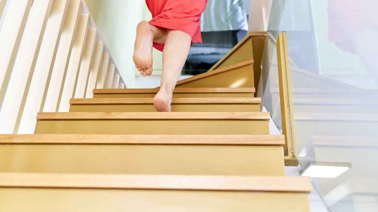 closeup of someone's feet running up an interior staircase