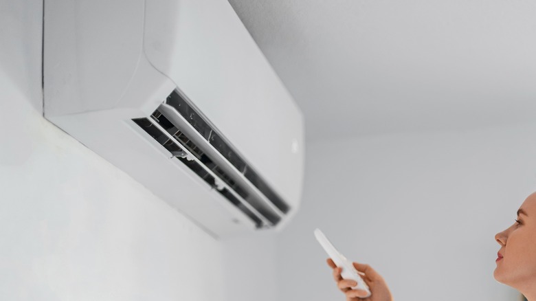 woman controlling aircon unit 
