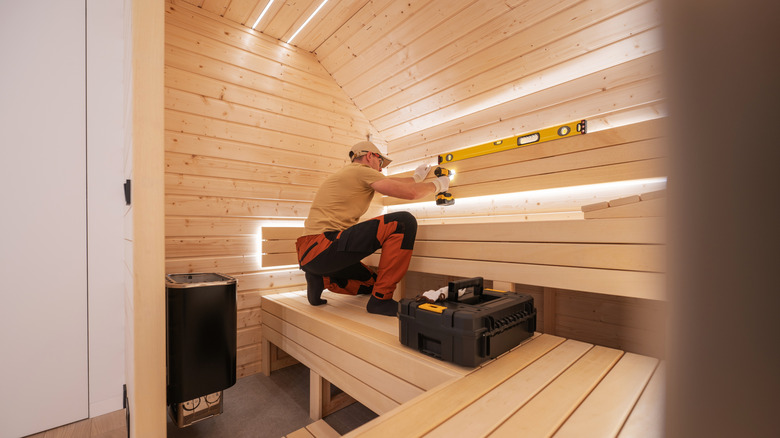 Person installing inside panelling in a sauna
