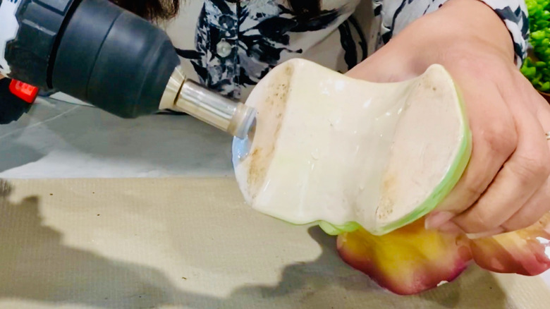Woman drills hole in the bottom of a vintage ceramic planter