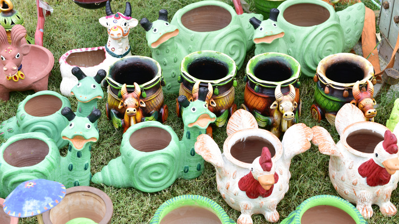 Collection of whimsical vintage planters on a grass lawn
