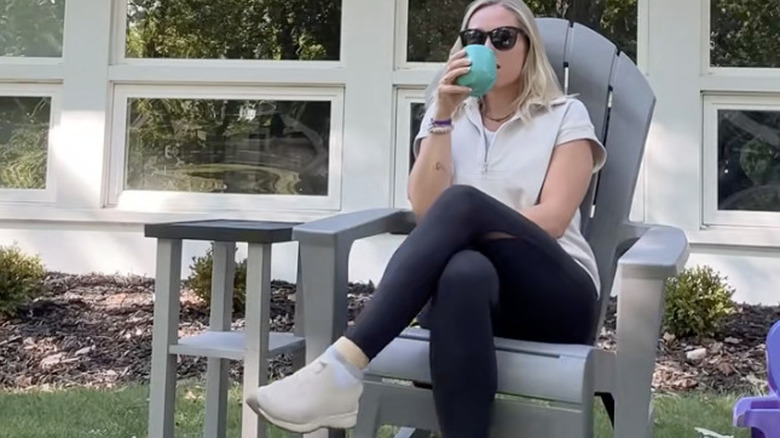 Creator Lindsey enjoying a beverage beside her adorable DIY outdoor table