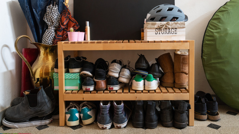 An cluttered old shoe rack in a hallway
