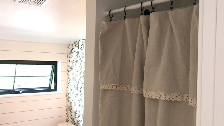 Shower curtain made from repurposed canvas drop cloth in small shower