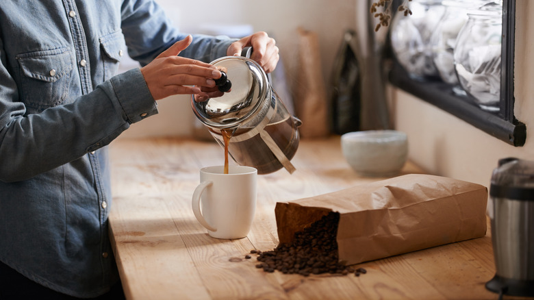 man pouring coffee in kitchen