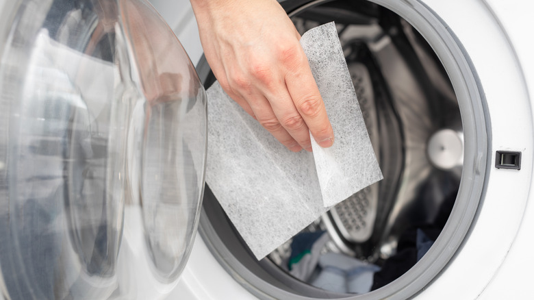 hand placing sheet in dryer