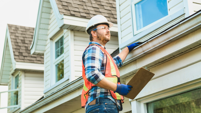 Contractor inspecting the roof of a house