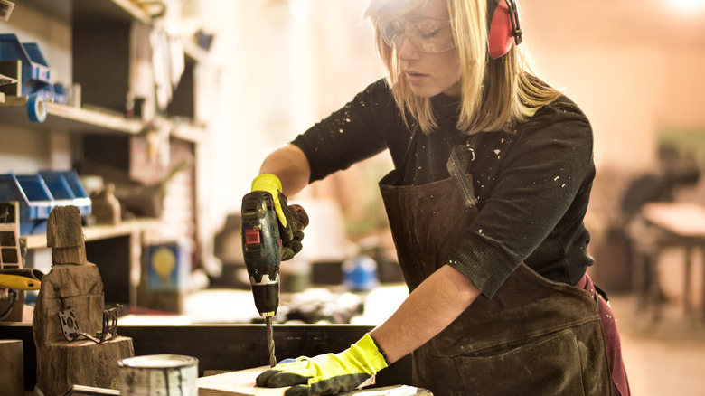 Woman drilling into a piece of wood