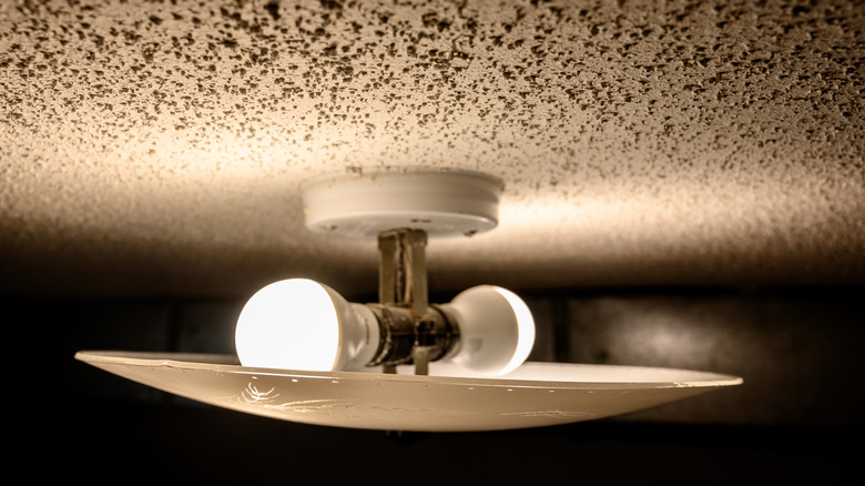 An LED light fixture illuminates a popcorn ceiling