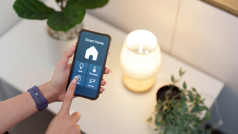 User controlling smart home lighting with smartphone