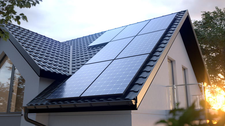 Solar panels on a roof with one corner of the bottom leftmost one partially in the shade from the roof