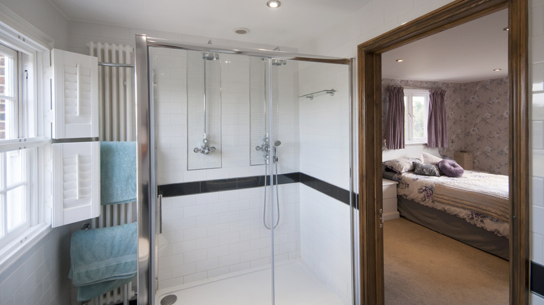 The interior of an en suite bathroom with a view of the neighboring bedroom