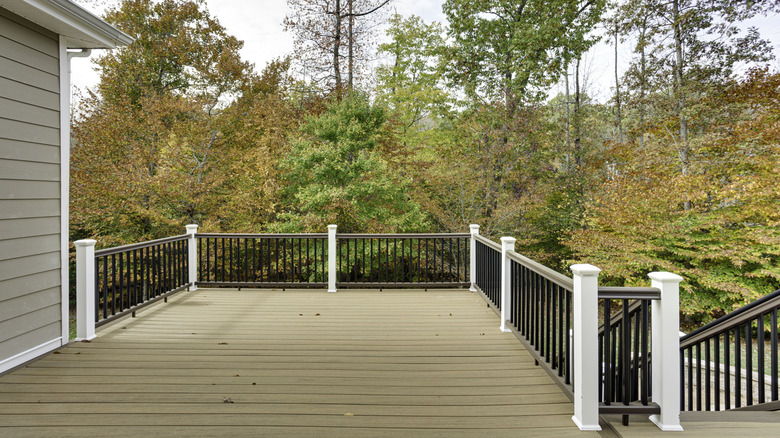 An outdoor deck with leaves on it surrounded by a forest