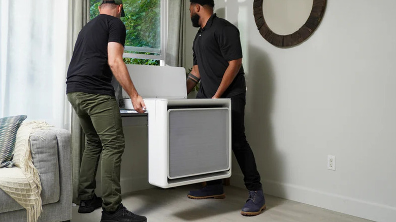 Two men fitting a Gradient all-weather window heat pump