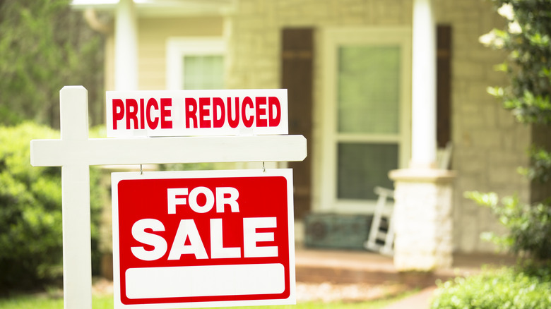 A house for sale with a price reduced sign