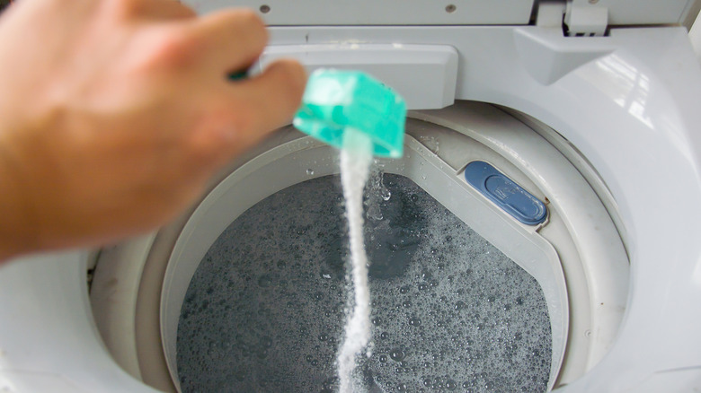 person adding detergent to washer