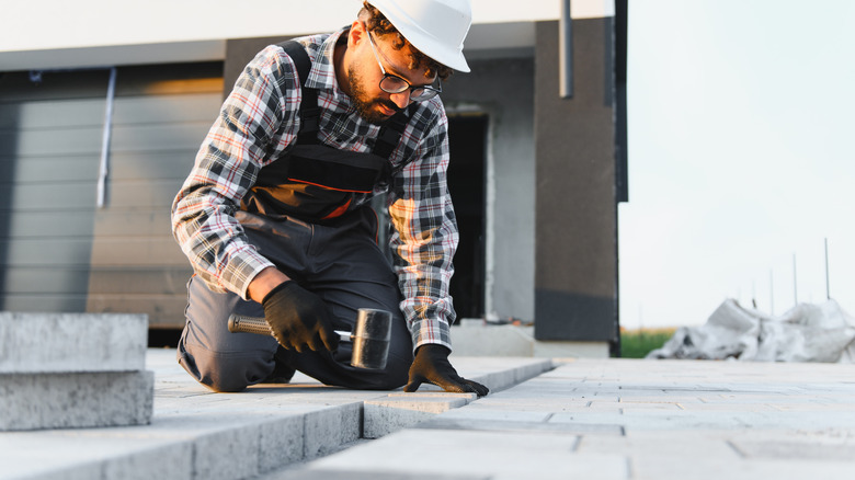 A professional installing permeable pavers in a home's driveway