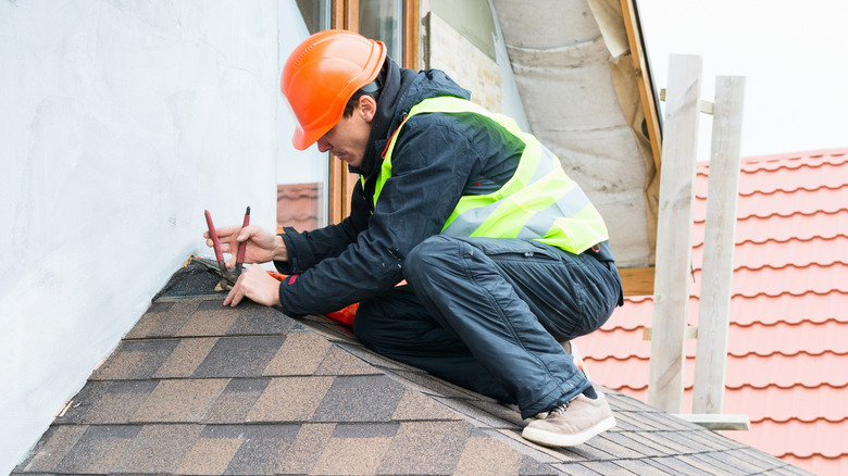 Roofer replacing shingles on a home