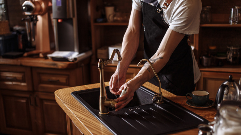 Man washing hands in prep sink