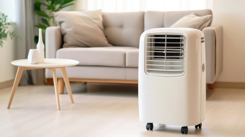 A portable air conditioner sits on a living room floor