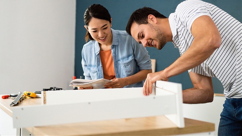 Man and woman putting together furniture