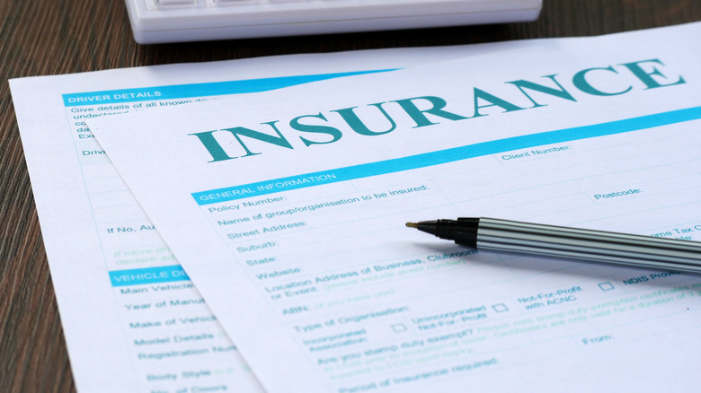 Closeup of blank insurance forms with a ballpoint pen on top